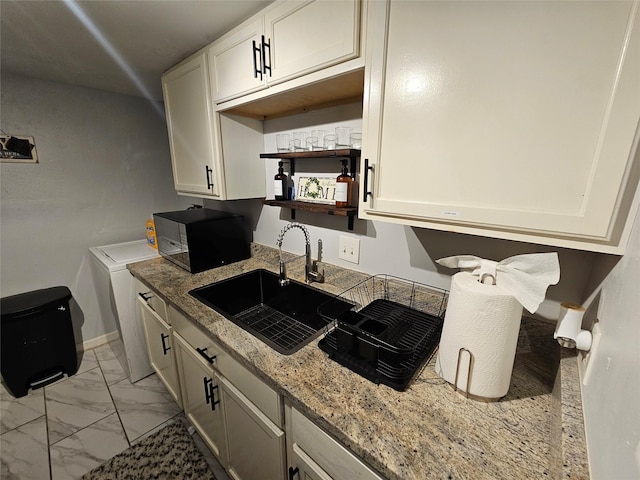 7886 Hamlet St, Houston, TX 77078 - kitchen featuring black microwave, a sink, light marble finish floors, light stone countertops, and white cabinetry
