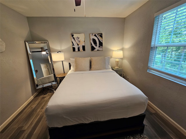 bedroom with dark hardwood / wood-style flooring and ceiling fan