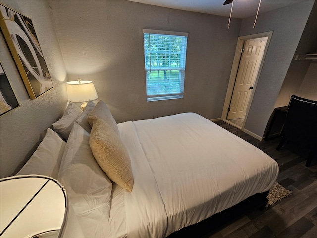 bedroom with dark hardwood / wood-style flooring and ceiling fan