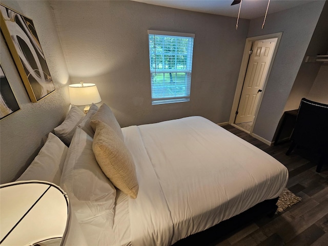 7886 Hamlet St, Houston, TX 77078 - bedroom with wood finished floors, a textured wall, and baseboards