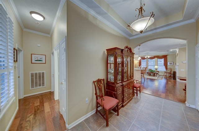 hallway with light wood-type flooring and crown molding