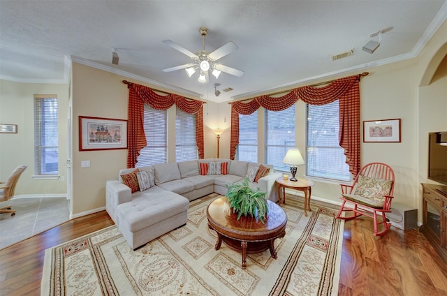 living room with hardwood / wood-style floors, a textured ceiling, ceiling fan, and crown molding