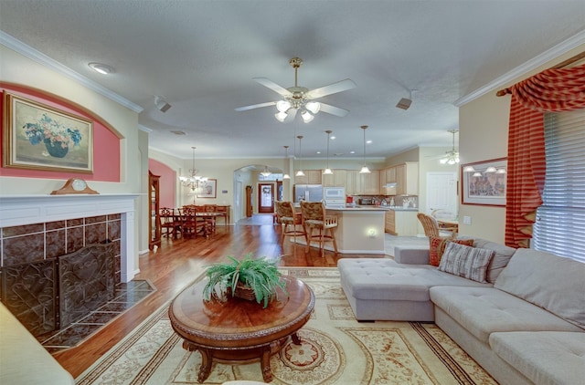 living room with a fireplace, hardwood / wood-style flooring, and ornamental molding