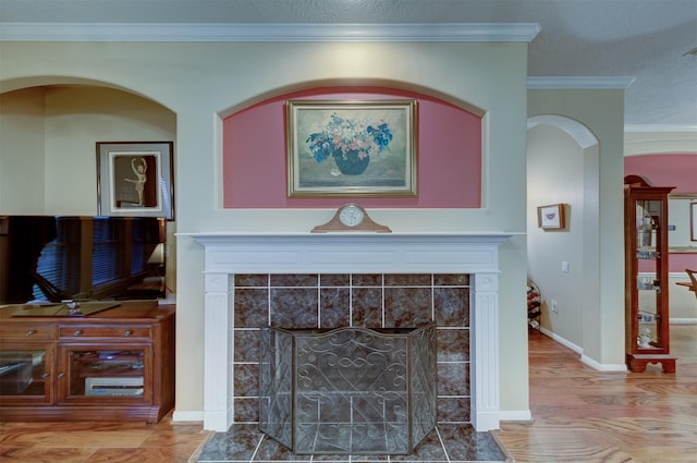 interior details with a fireplace, hardwood / wood-style floors, and crown molding