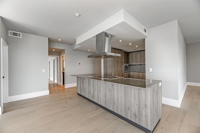 kitchen with black electric stovetop, light hardwood / wood-style floors, and range hood