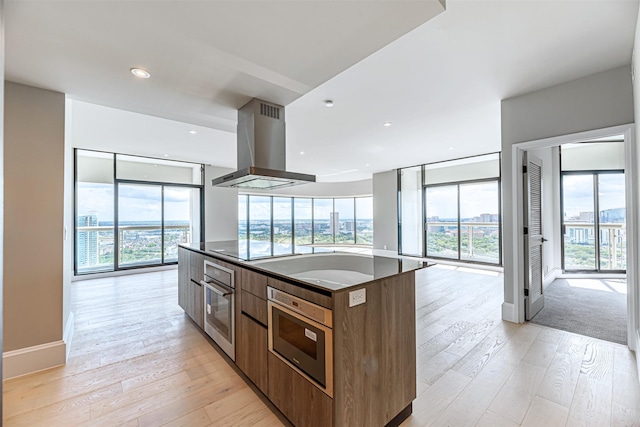 kitchen featuring a center island, extractor fan, plenty of natural light, and stainless steel oven