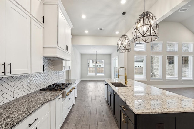 kitchen featuring a center island with sink, white cabinetry, sink, and appliances with stainless steel finishes