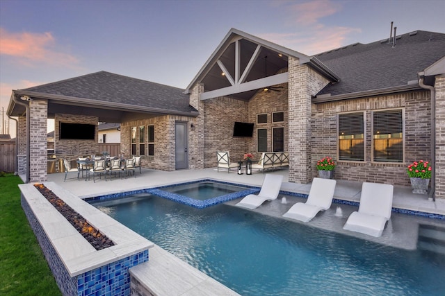 pool at dusk with an in ground hot tub, a patio, an outdoor living space with a fire pit, and ceiling fan