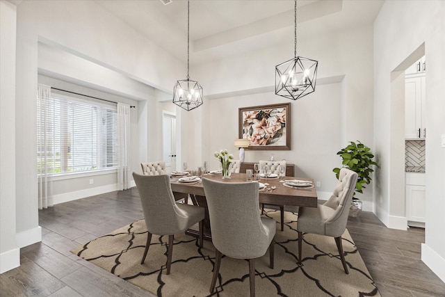 dining space featuring dark hardwood / wood-style flooring and an inviting chandelier