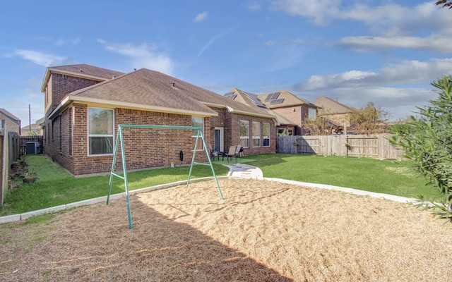 back of property with a playground and a lawn