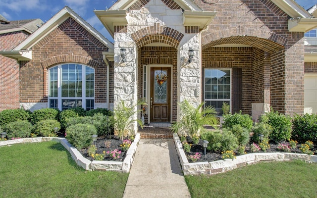 view of exterior entry with a lawn