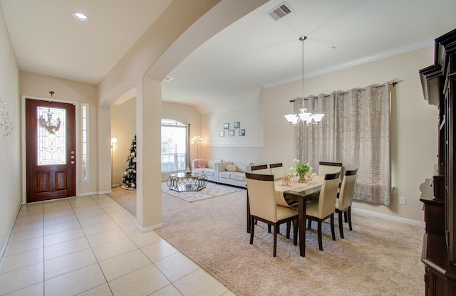 dining space with light colored carpet and a notable chandelier