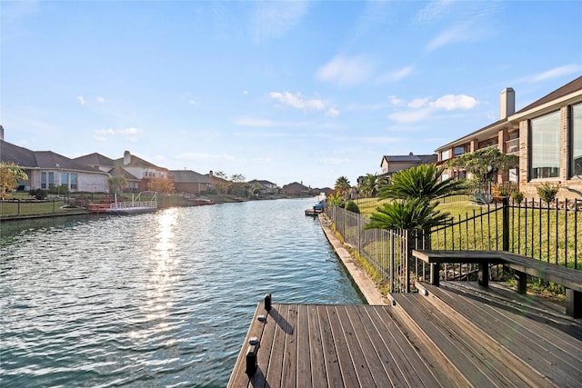 view of dock with a yard and a water view