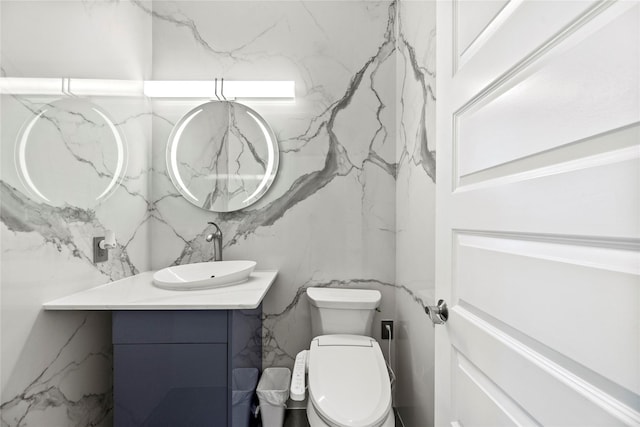 bathroom with vanity, toilet, and tile walls