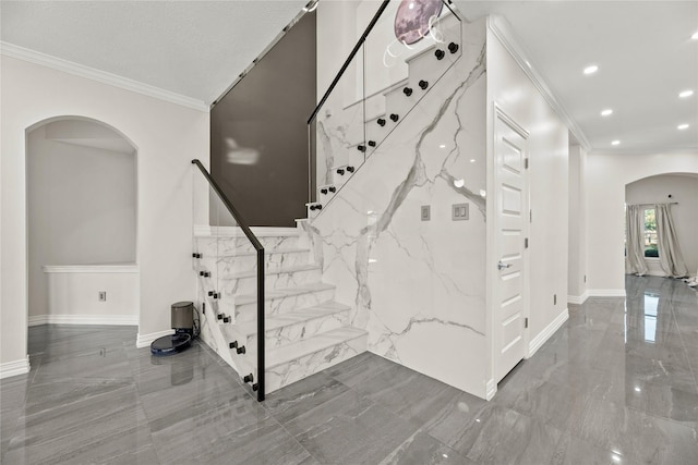 staircase featuring crown molding and a textured ceiling