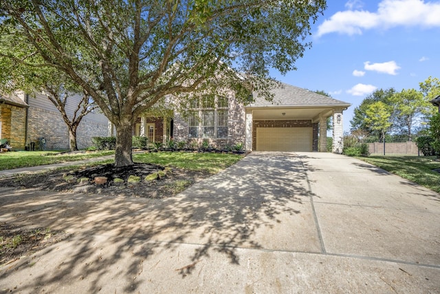 view of front of property with driveway, a garage, fence, and roof with shingles