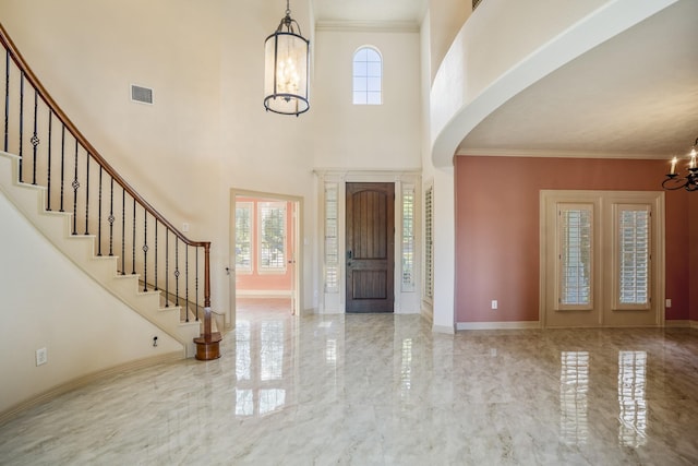 foyer featuring a chandelier, marble finish floor, visible vents, and a healthy amount of sunlight