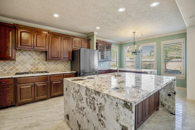 kitchen featuring crown molding, stainless steel appliances, glass insert cabinets, a sink, and light stone countertops