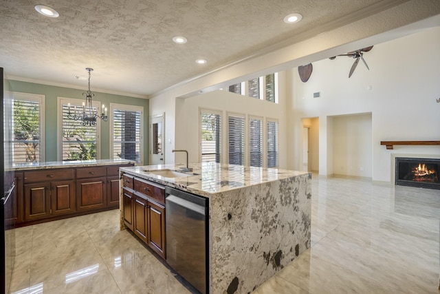 kitchen with a textured ceiling, a warm lit fireplace, a sink, stainless steel dishwasher, and crown molding