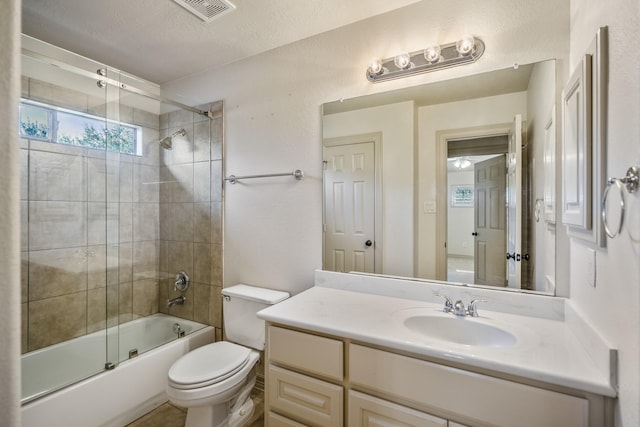 full bathroom featuring shower / bath combination with glass door, visible vents, toilet, vanity, and a textured ceiling