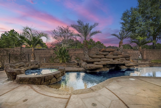 pool at dusk with a fenced in pool, fence, and a patio