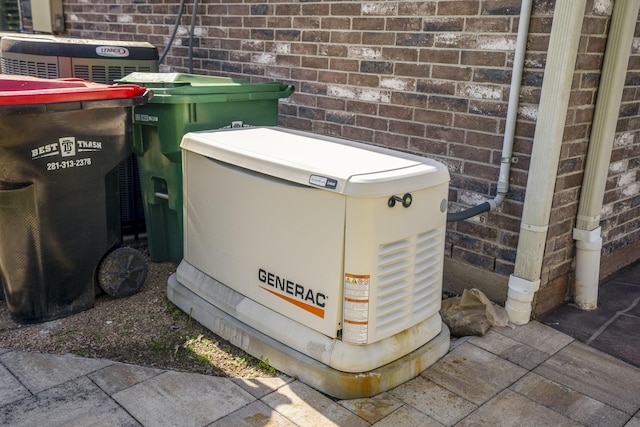 details with a power unit, brick siding, and central AC unit