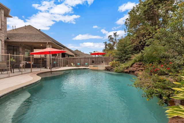 view of pool featuring a patio area and an in ground hot tub