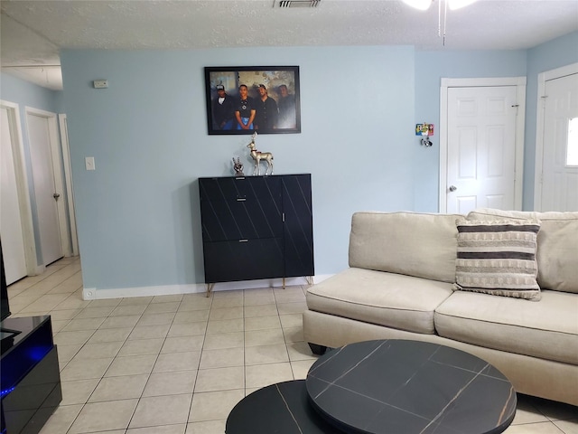 living room with light tile patterned flooring and a textured ceiling