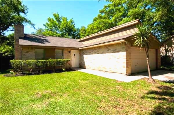 ranch-style house with a garage and a front lawn