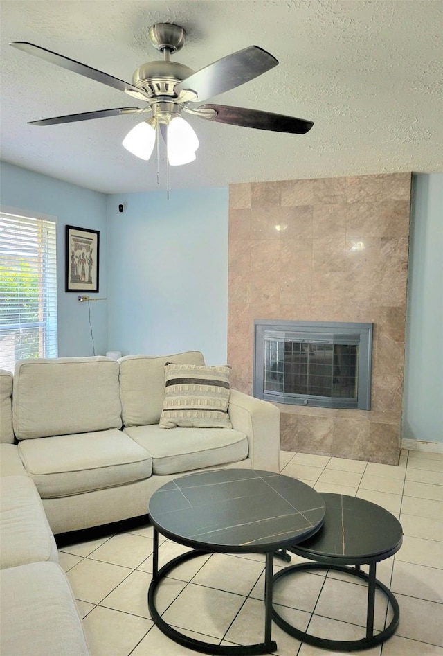 tiled living room featuring ceiling fan and a textured ceiling