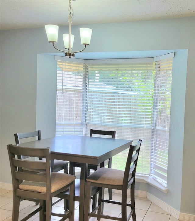 tiled dining room featuring a notable chandelier and plenty of natural light