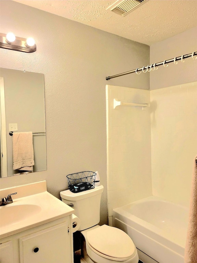 full bathroom featuring vanity, bathtub / shower combination, a textured ceiling, and toilet