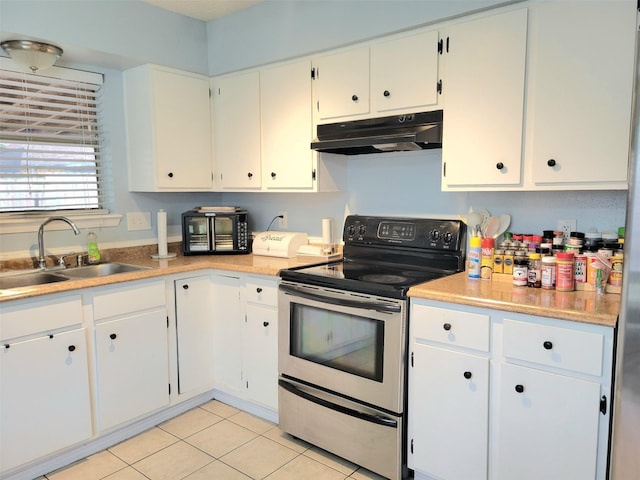 kitchen featuring white cabinetry, electric range, sink, and light tile patterned flooring