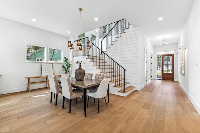 dining area with an inviting chandelier and light hardwood / wood-style flooring