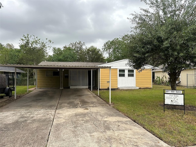 manufactured / mobile home with a front yard and a carport