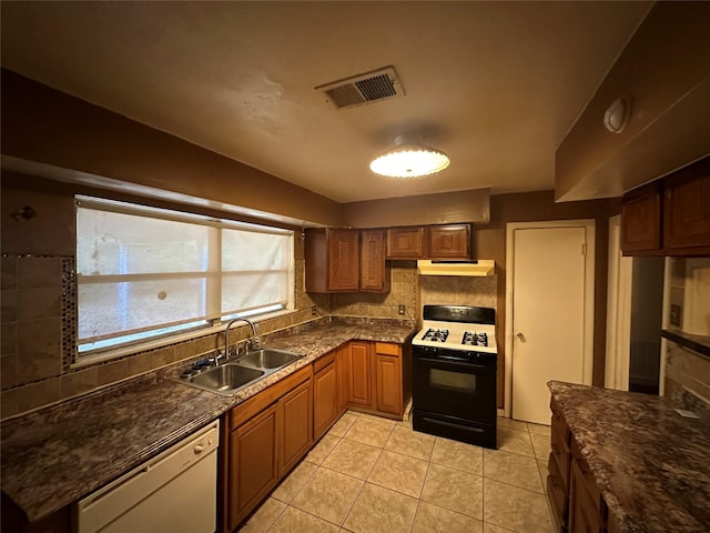 kitchen featuring light tile patterned floors, sink, white dishwasher, and black range with gas cooktop