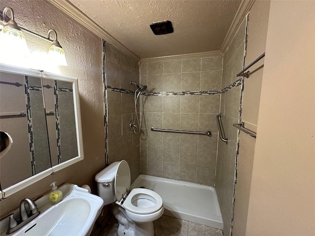 bathroom featuring sink, toilet, ornamental molding, tiled shower, and a textured ceiling