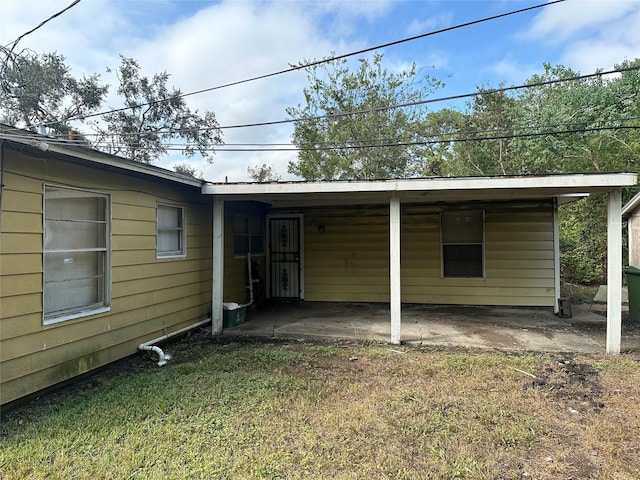 back of house featuring a patio area and a lawn