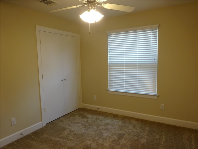 spare room featuring ceiling fan and carpet