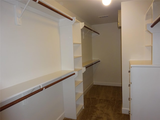 spacious closet featuring dark colored carpet