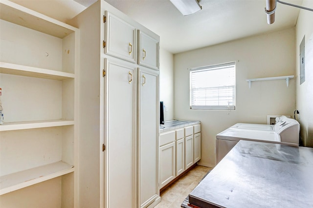 clothes washing area featuring cabinets, electric panel, and separate washer and dryer