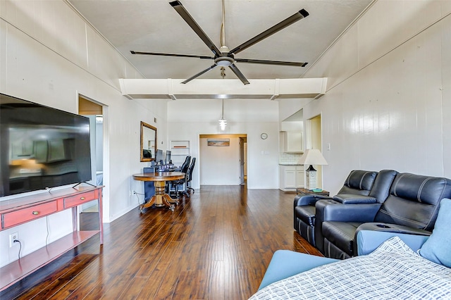 living room featuring ceiling fan, dark hardwood / wood-style flooring, and a towering ceiling