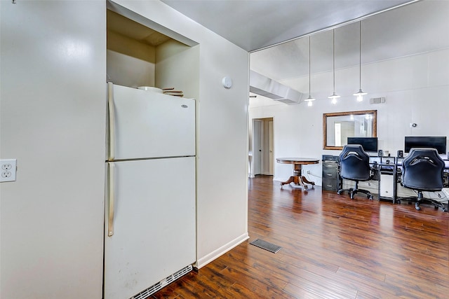 kitchen featuring white fridge and dark wood-type flooring