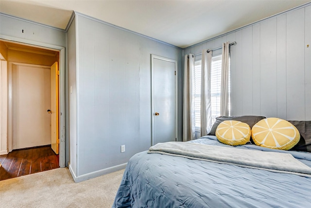 bedroom with wood walls and carpet