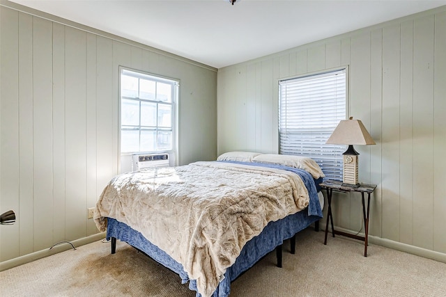 bedroom featuring wooden walls and light colored carpet