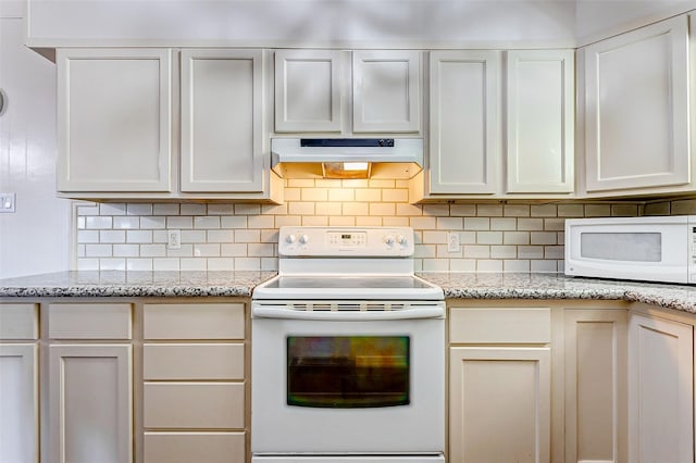 kitchen featuring light stone countertops, white appliances, white cabinets, and backsplash