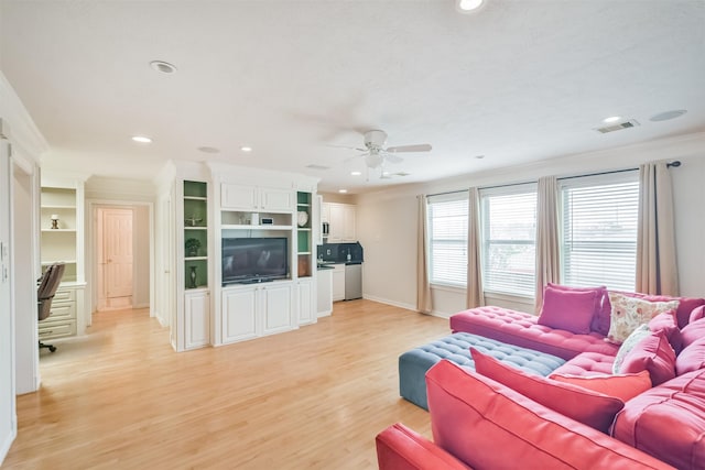 living room with ceiling fan, light wood-type flooring, and ornamental molding