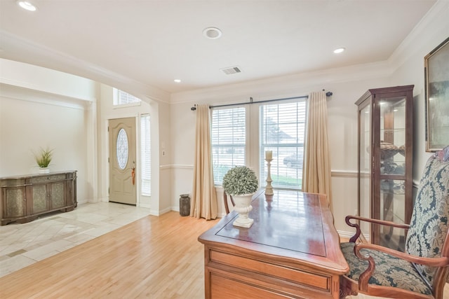 office area with light wood-type flooring and ornamental molding