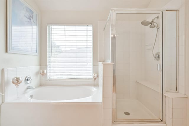 bathroom with shower with separate bathtub and a wealth of natural light