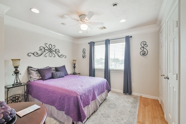 bedroom featuring ceiling fan, crown molding, and light hardwood / wood-style flooring